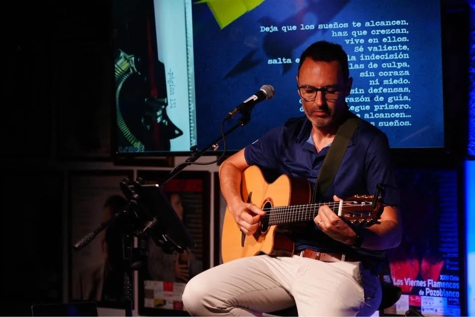 César canta y toca la guitarra en un espacio cultural.